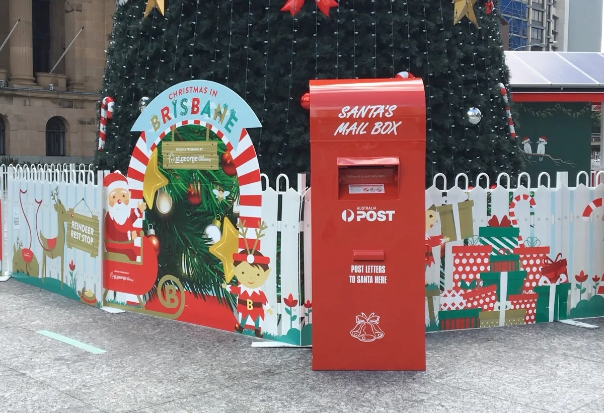 A festive red mailbox at an outdoor Christmas display
