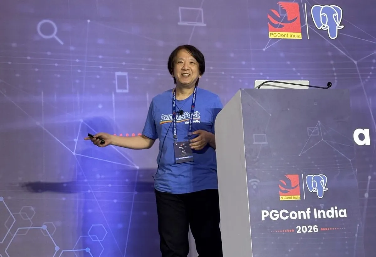 A speaker presenting on stage at PGConf India 2026